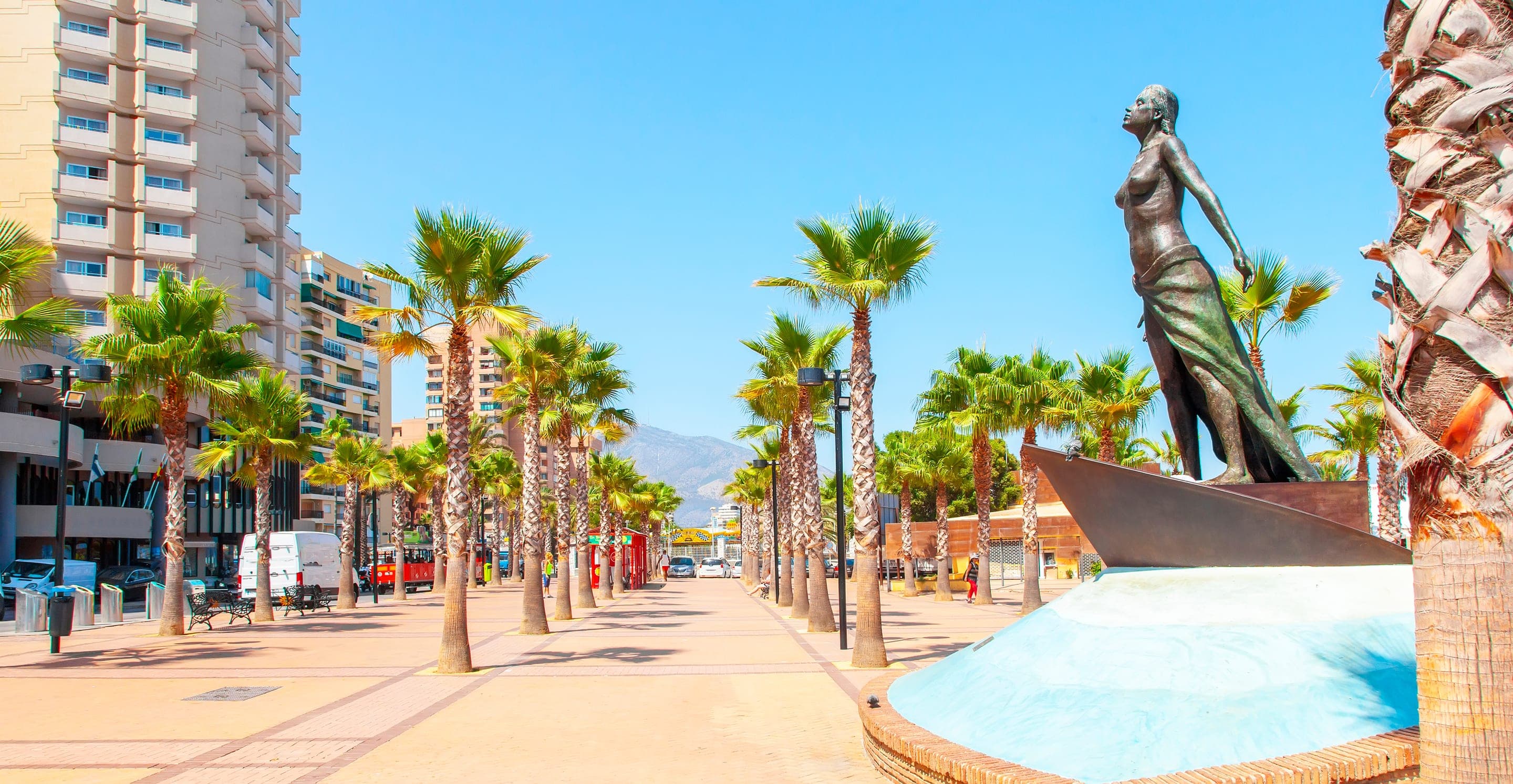 Palm-lined seafront promenade in Fuengirola with the Sierra de Mijas in the background